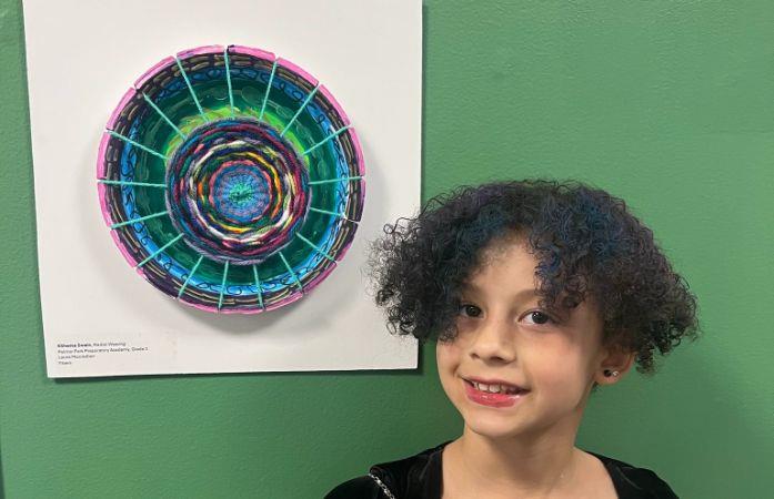  student posing with artwork
